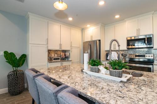 a kitchen with white cabinets and a marble counter top at One Particular Harbour Sound View 379-401 in Bradenton