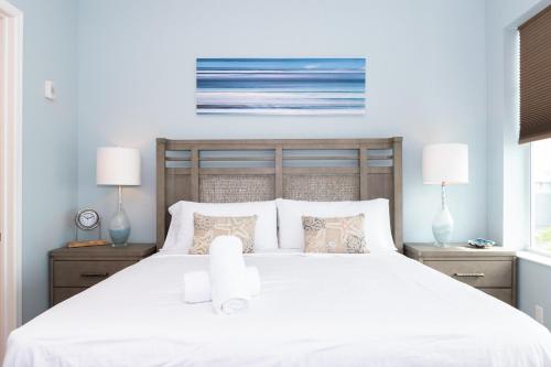a bedroom with a large white bed with two lamps at One Particular Harbour Sound View 379-401 in Bradenton