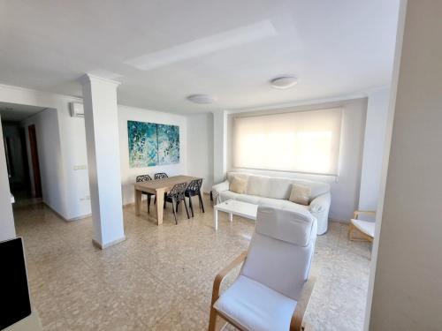 a living room with a couch and a table at Apartamento Duna - terraza con vistas al mar in Oliva