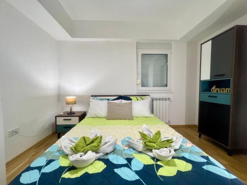 a bedroom with a bed with two flowers on it at Green Apartment in Skopje