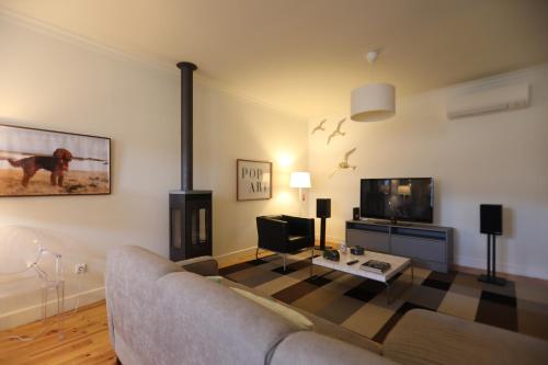 a living room with a couch and a tv at The Pine House in Peso da Régua