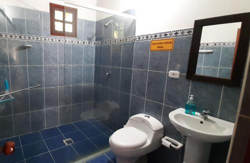 a bathroom with a toilet and a sink and a mirror at Villa Flor Blanca el Eden in Armenia