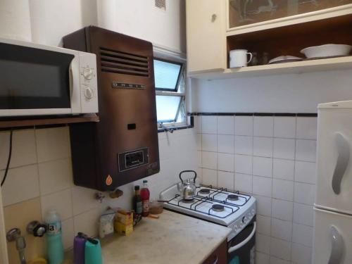 a small kitchen with a stove and a microwave at Departamento 2 ambientes Centro de Mar del Plata in Mar del Plata