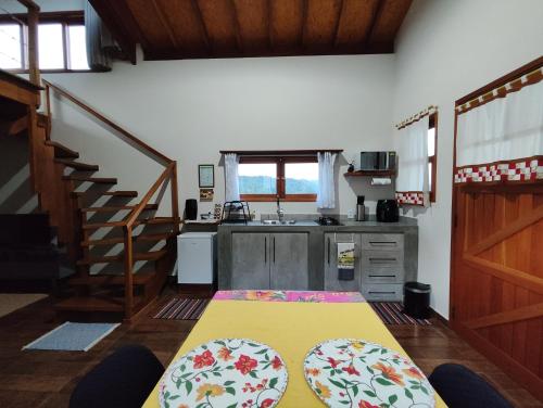 a kitchen with a table and a sink in a room at Chalés Ninho do Poeta in Gonçalves