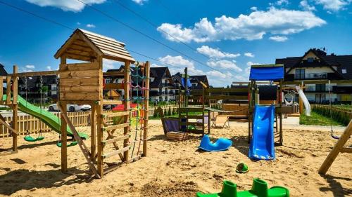 a playground in the sand with playground equipment at Apart No15 Grapa in Białka Tatrzańska