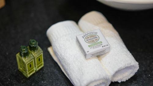 a pile of towels and a bottle of soap on a counter at Vila Natur in Sao Jorge