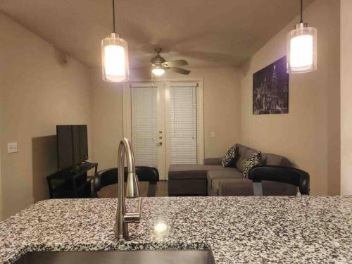 eine Küche mit einem Waschbecken und ein Wohnzimmer mit einem Sofa in der Unterkunft Home at Energy corridor in Houston