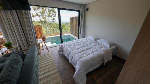 a bedroom with a bed and a view of a pool at Vila Natur in Sao Jorge