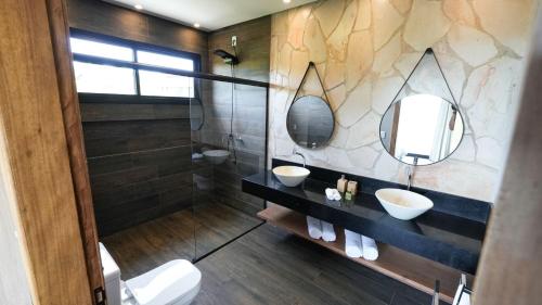 uma casa de banho com dois lavatórios e dois espelhos em Vila Natur em São Jorge