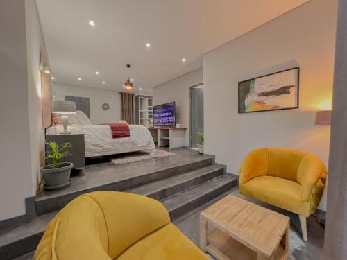 1 dormitorio con 1 cama y 2 sillas en Amoris Guesthouse - Sandton, en Johannesburgo
