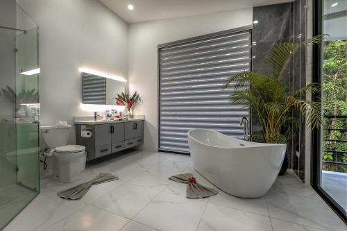 y baño con bañera, aseo y lavamanos. en Casa Presidente (5 bed/5 bath/AC/infinity pool) en Punta Uva