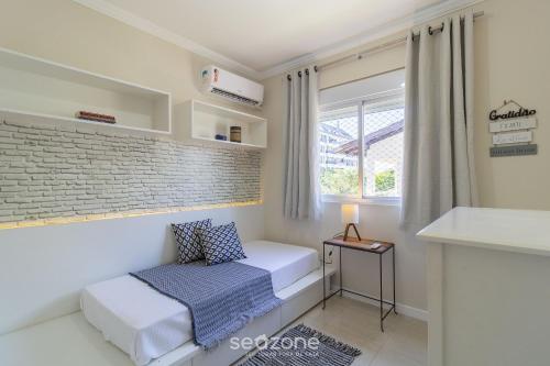 - une petite chambre avec un lit et une fenêtre dans l'établissement Lindo apto a 3 minutos da praia de Jurerê VMA101, à Florianópolis