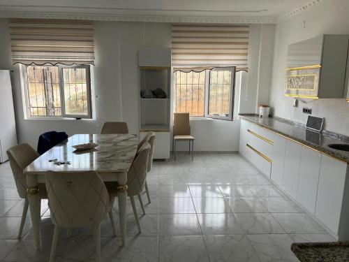 een keuken en eetkamer met een tafel en stoelen bij Villa Leyla 