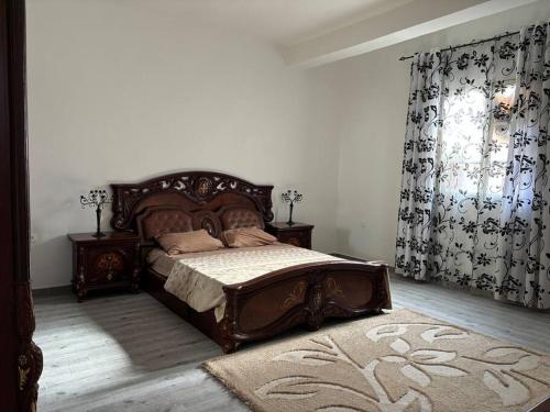 1 dormitorio con 1 cama, 2 mesas y cortinas en Appartement Oran en Orán