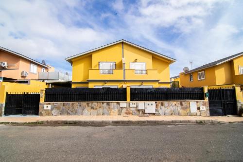 una casa amarilla con una valla delante de ella en The Safe Point Residential Castillo, en Castillo del Romeral
