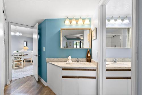a bathroom with two sinks and a blue wall at Bayview Condo B in Bradenton Beach