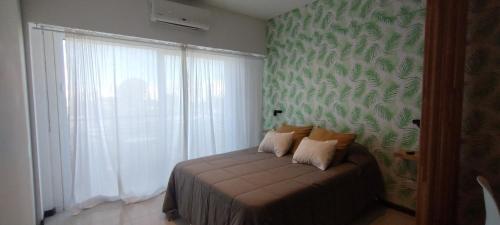 um quarto com uma cama com uma parede verde em Balcón de lecheros em Buenos Aires