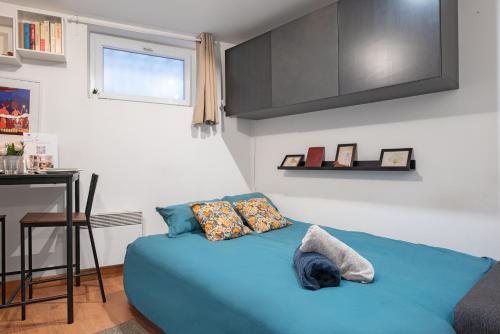 - un lit bleu dans une petite chambre avec une table dans l'établissement Studio cosy Toulouse centre, à Toulouse
