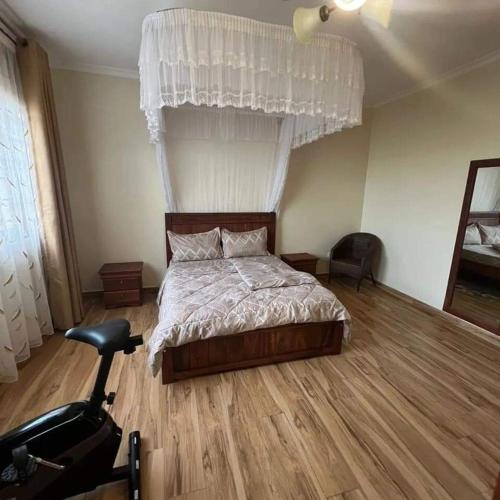 um quarto com uma cama e uma cadeira em Nalya Apartments em Kampala