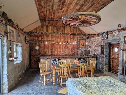 Moig Lodge - 7 Double Bedroom Barn Conversion في ليميريك: غرفة طعام بجدران خشبية وطاولة وكراسي