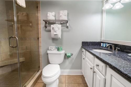 a bathroom with a toilet and a sink and a shower at Ocean Breeze Oceanfront Tower King Room 2nd Fl in Pawleys Island
