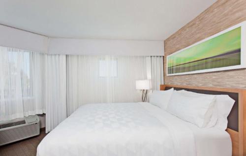 a large white bed in a hotel room at Holiday Inn Palmdale-Lancaster by IHG in Palmdale