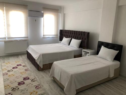 1 Schlafzimmer mit 2 Betten und 2 Fenstern in der Unterkunft EDİRNE GUEST HOME HOSTEL in Edirne