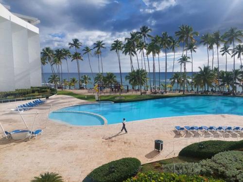 a man walks by a swimming pool at a resort at Apartamento en Juan Dolió, Marbella in La Francia