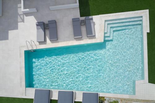 an overhead view of a swimming pool with chairs at Aelia in Agios Petros