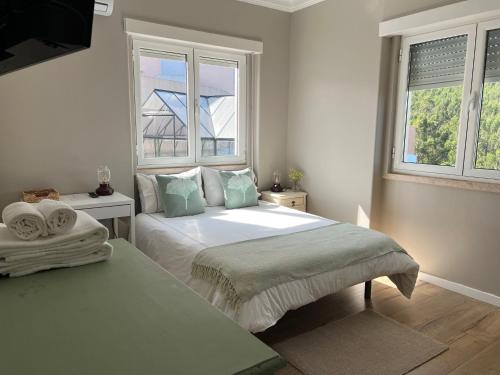 - une chambre avec un grand lit et 2 fenêtres dans l'établissement Quinta Janelas do Vale, à Abrantes