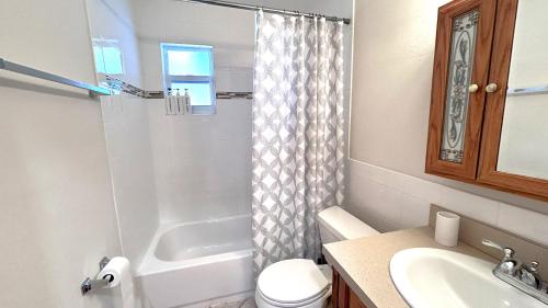een badkamer met een toilet, een wastafel en een douche bij LuxCoral - 4 Min walk to beach! in Cape Canaveral