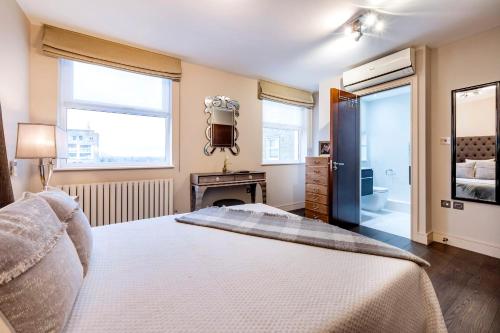 1 dormitorio con 1 cama grande y chimenea en CAMDEN Lux Apartment-Hosted by Sweetstay, en Londres