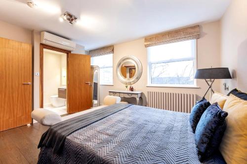 a bedroom with a large bed and a mirror at CAMDEN Lux Suite-Hosted by Sweetstay in London