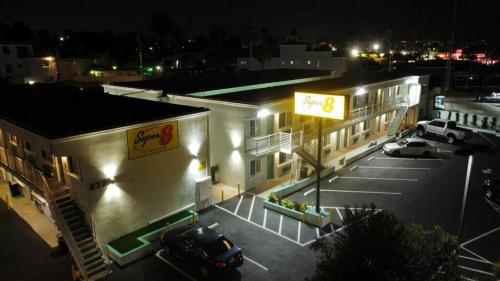a parking lot in front of a building at night at Super 8 by Wyndham Oceanside Downtown in Oceanside