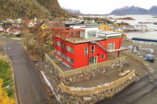 un edificio rojo al lado de una carretera en Leilighet med egen uteplass og utsikt. Parkering., en Svolvær