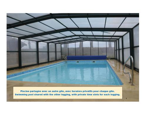 a large swimming pool with a metal structure at Maison 10p avec piscine, chauffée et partagée avec 1 autre gîte, horaires privatifs pour chaque gîte - Réservation sur https auxportesdetretat fr in Villainville