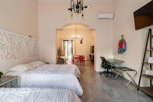 - une chambre avec deux lits et une salle à manger dans l'établissement Villas Candita, à Mérida