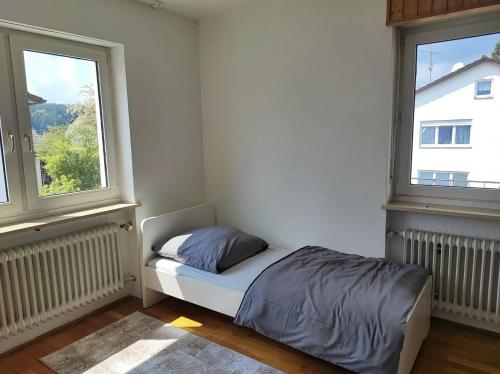 um pequeno quarto com uma cama e 2 janelas em Große möblierte Wohnung im Zentrum von Lage em Lage
