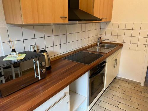 uma cozinha com um lavatório e uma bancada em Große möblierte Wohnung im Zentrum von Lage em Lage