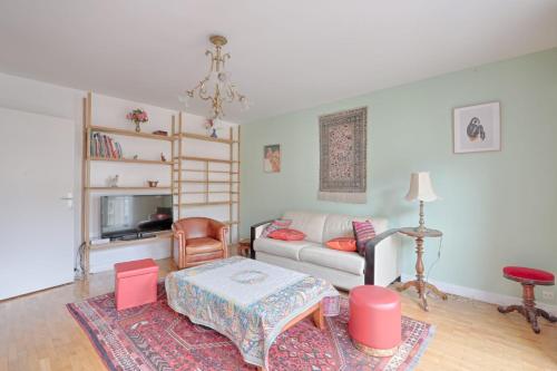 un salon avec un canapé et une table dans l'établissement Appartement Martino - Welkeys, à Paris