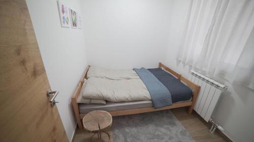 a small bed in a room with a window at Madulo apartman in Jahorina