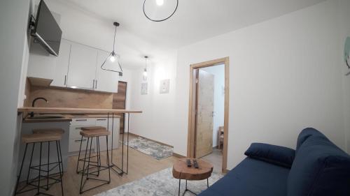 a living room with a blue couch and a kitchen at Madulo apartman in Jahorina