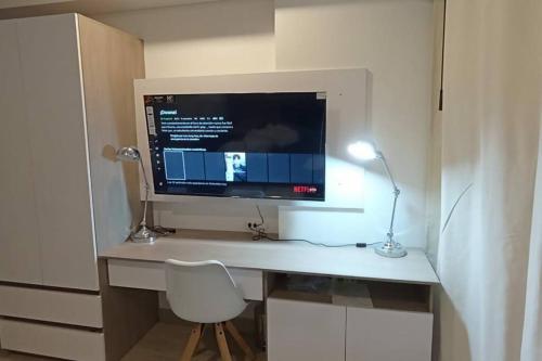 un monitor de ordenador sentado en un escritorio con una silla en New Beach loft in Cartagena close to the airport, en Cartagena de Indias