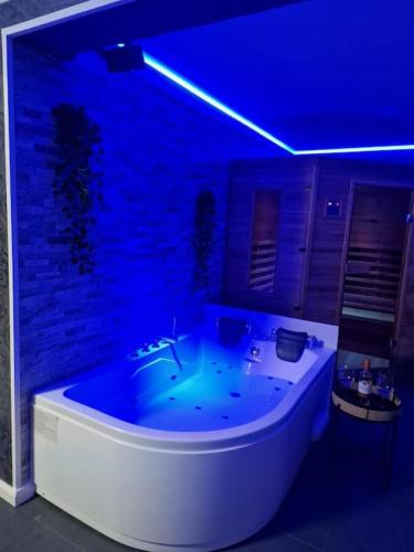 un'illuminazione blu in un bagno con vasca di Relaxation House: Jacuzzi, Sauna a Übach-Palenberg