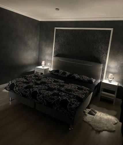 - une chambre avec un lit et 2 tables de chevet dans l'établissement Relaxation House: Jacuzzi, Sauna, à Übach-Palenberg