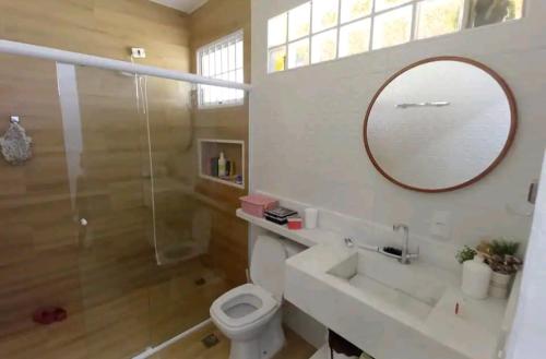 a bathroom with a toilet and a sink and a mirror at Linda chácara em Ibiúna in Ibiúna