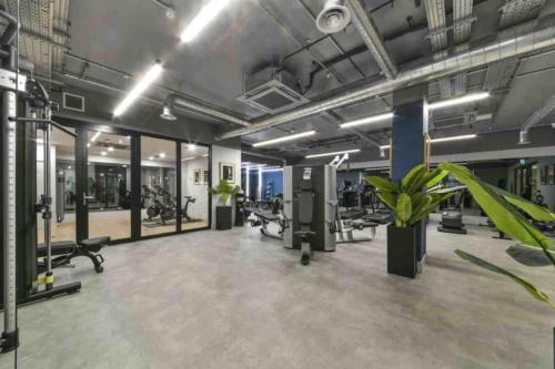 a gym with treadmills and elliptical machines at Brand New 1 Bed Modern Apartment in London