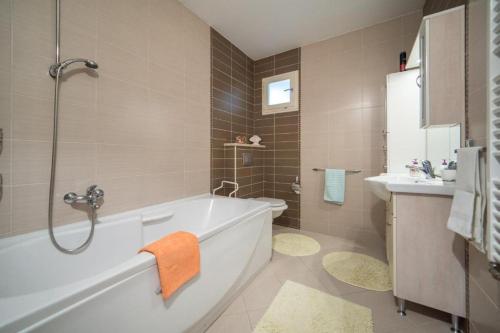 a bathroom with a bath tub and a sink at Apartment Ela with private jacuzzi in Podgora