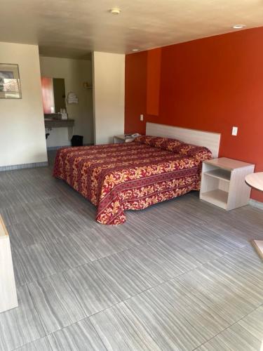 - une chambre avec un grand lit et un mur rouge dans l'établissement Star Lodge Motel-Oceanside, à Vista