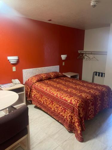 - une chambre dotée d'un lit avec un mur orange dans l'établissement Star Lodge Motel-Oceanside, à Vista